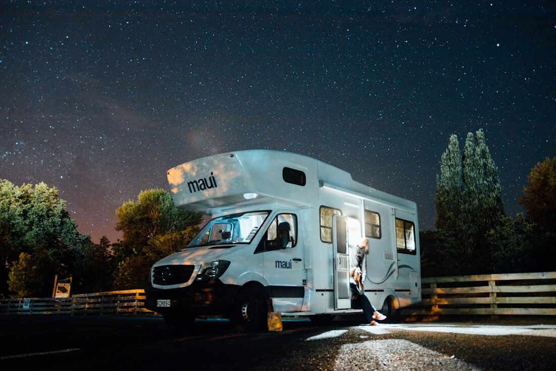 A motorhome parked outdoors at night under a clear sky.
